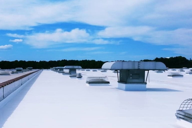 Above All Construction displays an image that showcases their ability to apply TPO roofing on large commercial warehouse buildings.